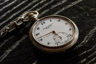 The silver round simulation pocket watch on the table
